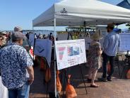 The Project team talks to people visiting the July 20th Concerts on the Dock booth